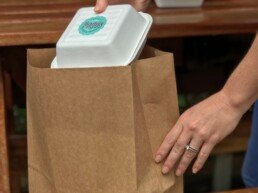 person holding brown paper bag